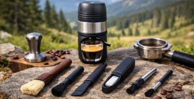 Cepillos de limpieza para cafeteras espresso colocados sobre una roca en un entorno rural junto a una cafetera espresso portátil y granos de café